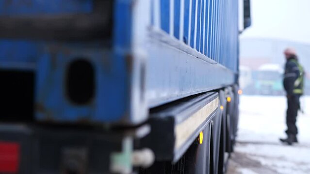 crane loading a container onto a truck in winter. hard work concept