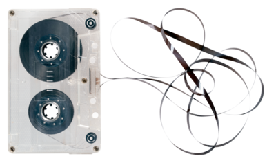 Audio cassette with unrolled tape on isolated background.