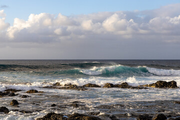 Fototapeta na wymiar Waves rolling in over volcanic rock in Puert de las Nieves, Gran Canaria, Spain