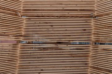 Stacks of boards, board flooring in a sawmill. Warehouse for cutting boards in a sawmill outdoors. Stack of wooden blanks construction material wood timber. Industry.