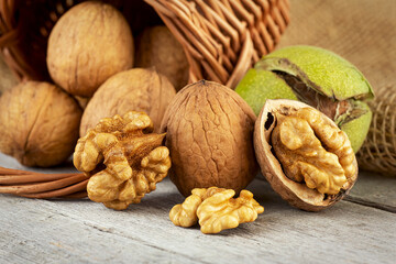 Walnut kernels and whole walnuts on rustic wooden table. Healthy walnuts.