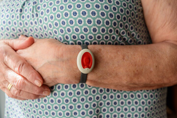 Elderly woman with home care bracelet. - obrazy, fototapety, plakaty