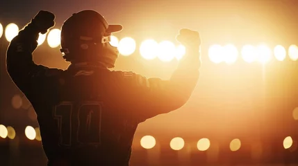 Poster Silhouette of race car driver celebrating the win in a race against bright stadium lights. 100 FPS slow motion shot © Orxan