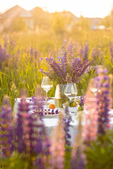 Private wedding party for two, table set with floral decor and greenery, fruits, wine in lupine...