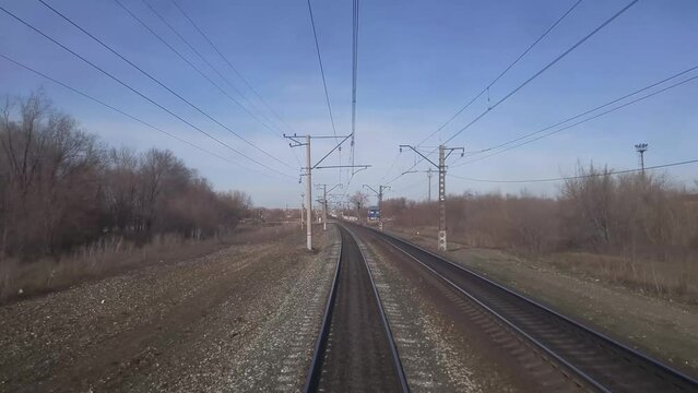 View from last wagon of train to road with car, rail and forest