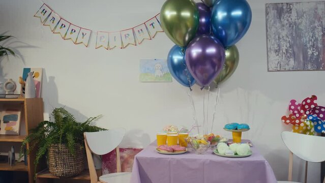 No people footage of empty room with balloons, garland and table with different sweets decorated for birthday of kid