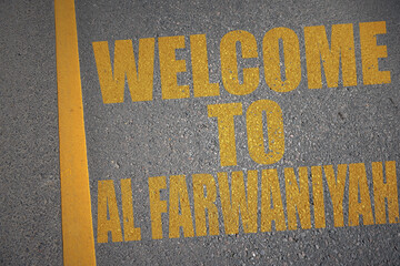 asphalt road with text welcome to Al Farwaniyah near yellow line.