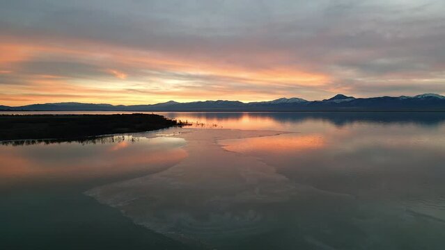 Flying over thin ice on Utah lake during sunset in the winter.