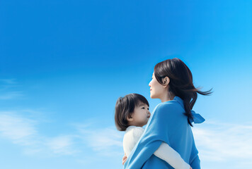 close up photo of mother and daughter. blue sky with white clouds. 