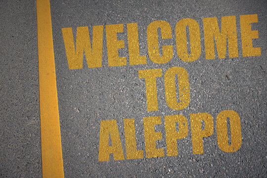 asphalt road with text welcome to Aleppo near yellow line.