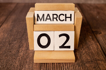 March 02 calendar date text on white wooden block with stationeries on wooden desk. Calendar date...