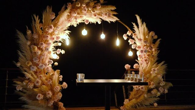 wedding arch of white rose flowers on the river bank before the wedding ceremony of the bride and groom, festive romantic boho style decor