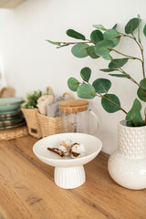 a wooden table with a vase, plates and other decor