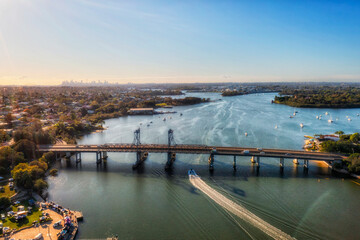 Parramatta river waterway at Ryde bridge of City of Ryde - aerial view towards Sydney city CBD.