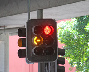 Traffic lights under a freeway showing red stop light and orange arrow