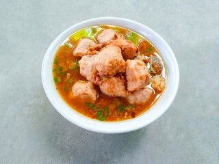 bakso, meatballs served in a bowl on a gray background. Meatball soup with marrow, chicken bones and spring onions without noodles or vermicelli. savory and delicious soupy food.