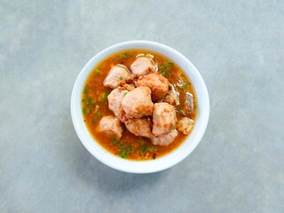 bakso, meatballs served in a bowl on a gray background. Meatball soup with marrow, chicken bones and spring onions without noodles or vermicelli. savory and delicious soupy food.