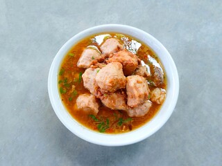 chicken curry with ricebakso, meatballs served in a bowl on a gray background. Meatball soup with marrow, chicken bones and spring onions without noodles or vermicelli. savory and delicious soupy food