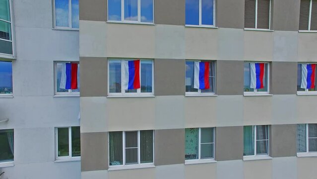 Six flags of Russian Federation are on facade of residential house 