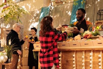 Farmers market vendor giving fresh organic produce box to customer, natural bio products. Woman buying healthy locally grown fruits and vegetables at roadside stand, small business.