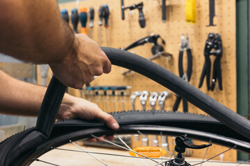 closeup hand removing flat tire from bike in workshop