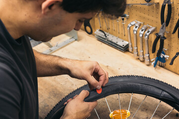 bicycle mechanic covering puncture with a patch