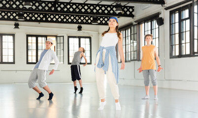 Active teenage dancers having contemporary dance training at dance hall