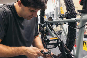 young mechanic repairing bicycle chain