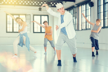 Portrait of teenage boy performing hip hop elements at group dance training in studio