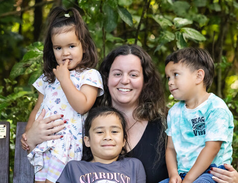 A close up image of a multiracial young family in New Zealand posing for their portrait.