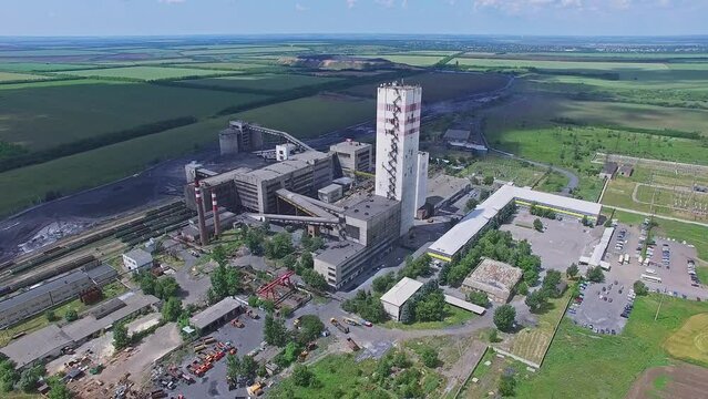 Large colliery among fields at sunny summer day. Aerial view