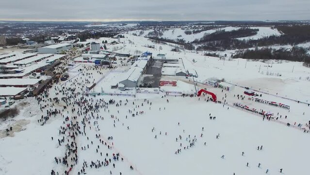 Many people walk by start place of ski race Lyzhnia Rossii at winter
