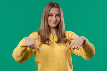 Pretty woman pointing down to advertising area. Teal. click to subscribe below