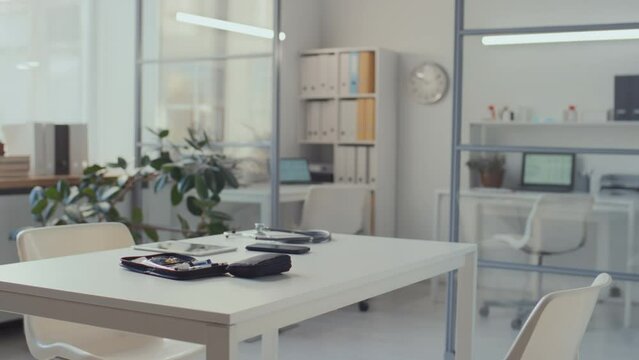 Full Pan No People Shot Of Empty Office Of Medical Doctor In Morning Before Work, With Diabetes Test Kit, Tablet Computer, Smartphone On Desk, And Cabinet With Patient Files