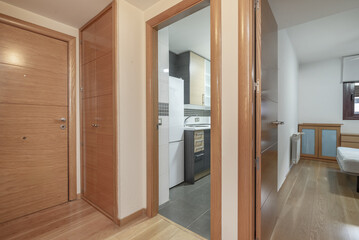 Hallway of a residential house with oak wood doors, access to kitchen and bedroom