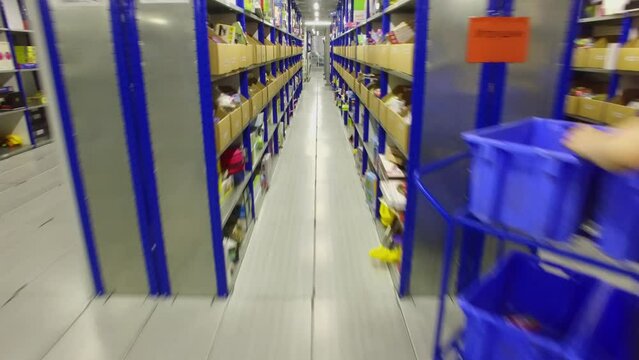Woman work among shelves with goods in Ozon company warehouse