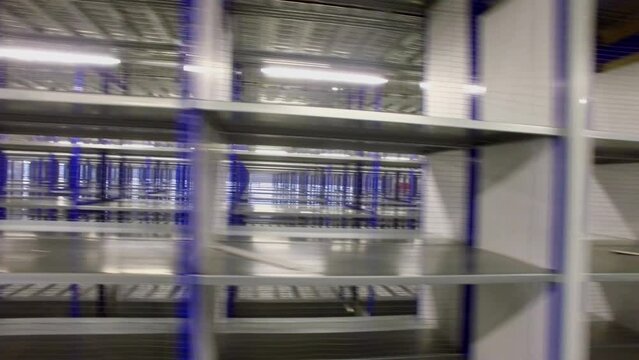 Storage hangar with rows of empty shelves in logistic center