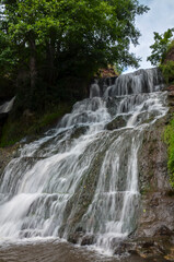 Fototapeta na wymiar Scenic view of cascading 16 meters Dzhurinsky waterfall on the river Dzhurin. It is the largest in Ukraine plain waterfall. Nyrkiv, Ternopil region, Ukraine
