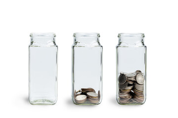 Glass jar of coins isolated on white background. jars with different level of coins. Growing...