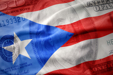 waving colorful flag of puerto rico on a american dollar money background. finance concept.
