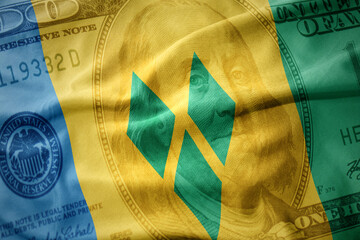 waving colorful flag of saint vincent and the grenadines on a american dollar money background....