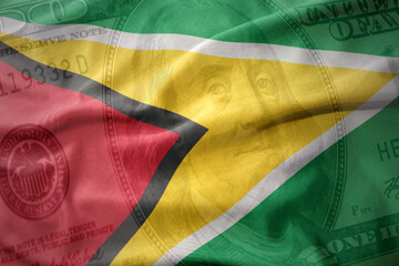 waving colorful flag of guyana on a american dollar money background. finance concept.