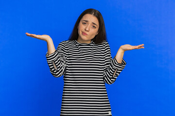 No idea, I don't know answer. Puzzled clueless uncertain Caucasian young woman in striped blouse...