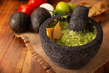 Guacamole. Avocado dip with tortilla chips also called Nachos served in a bowl made with volcanic...