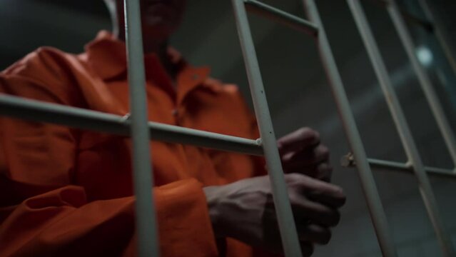 Close up view of hands of unrecognizable prison guard taking handcuffs off female inmate in cell
