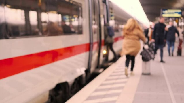 passengers late, running to German railway train, platform Frankfurt am Main station, out of focus video, people with luggage and backpack go to board, boarding travelers in cars, Frankfurt, Germany