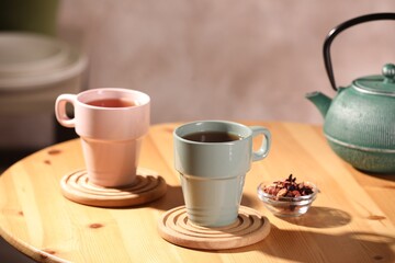 Aromatic tea, dry flower petals and teapot on wooden table