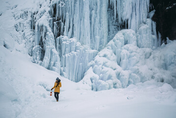 Snoqualmie Pass: An outdoor enthusiast admires the icy, snowy scene of Franklin Falls in winter
