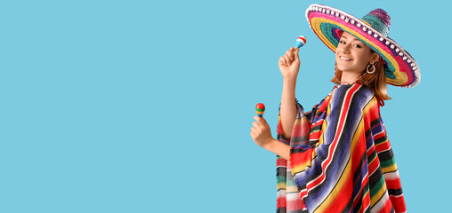 Beautiful Mexican woman in sombrero hat and with maracas on light blue background with space for...