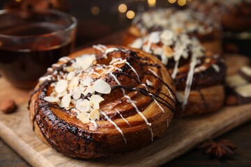 Delicious rolls with toppings and nuts on wooden table, closeup. Sweet buns